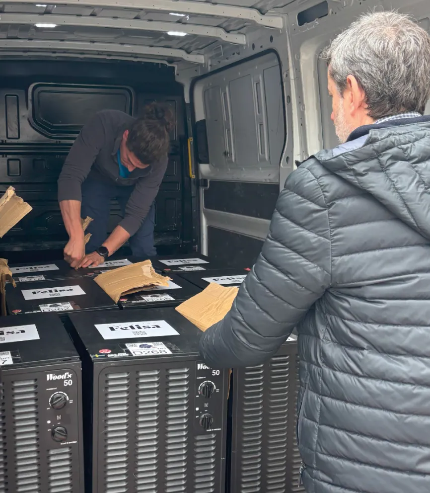 Voluntarios cargando deshumidificadores etiquetados con el logo de Felisa en una furgoneta