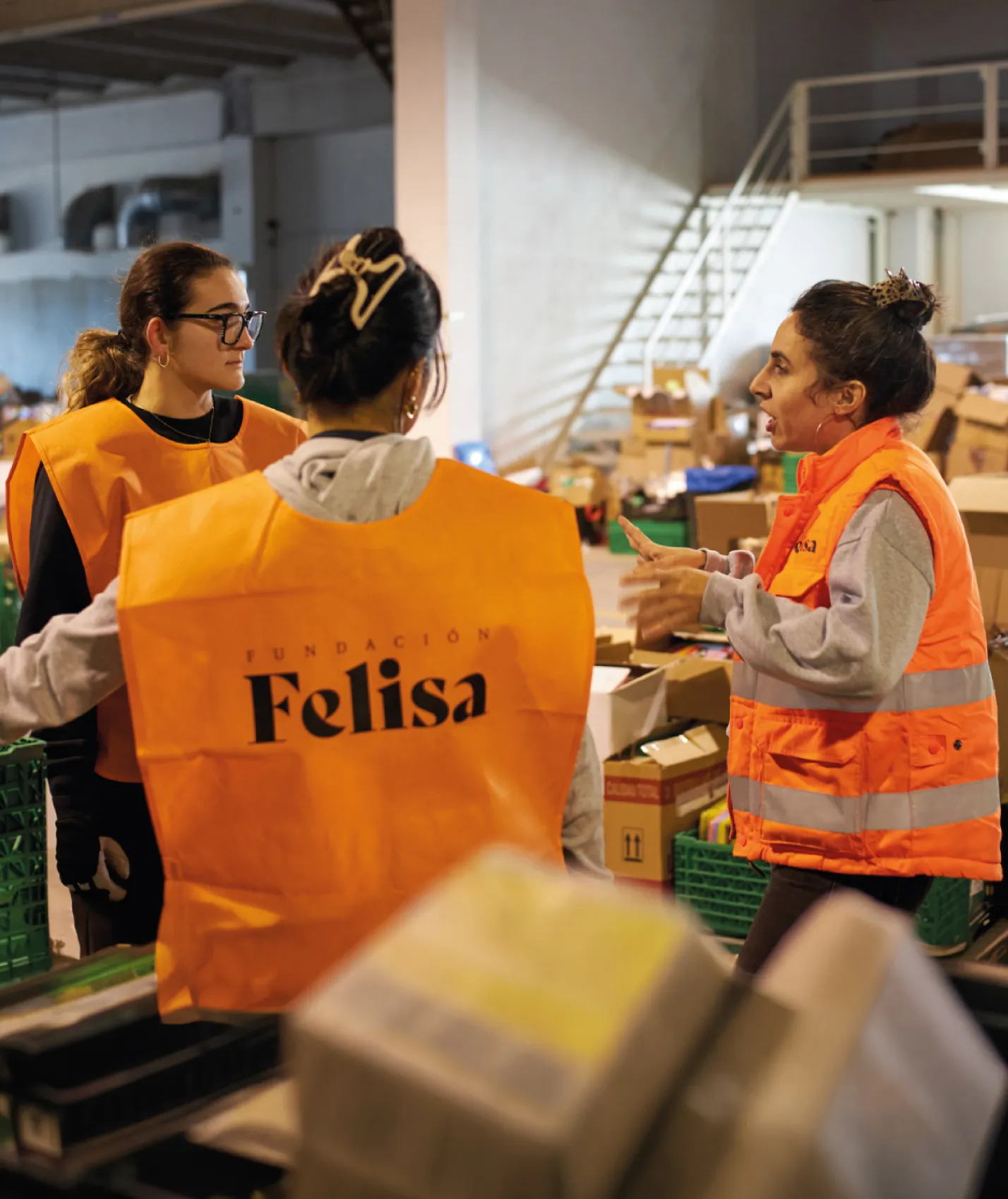 Voluntarias con chaleco de Fundación Felisa clasificando donaciones en una nave