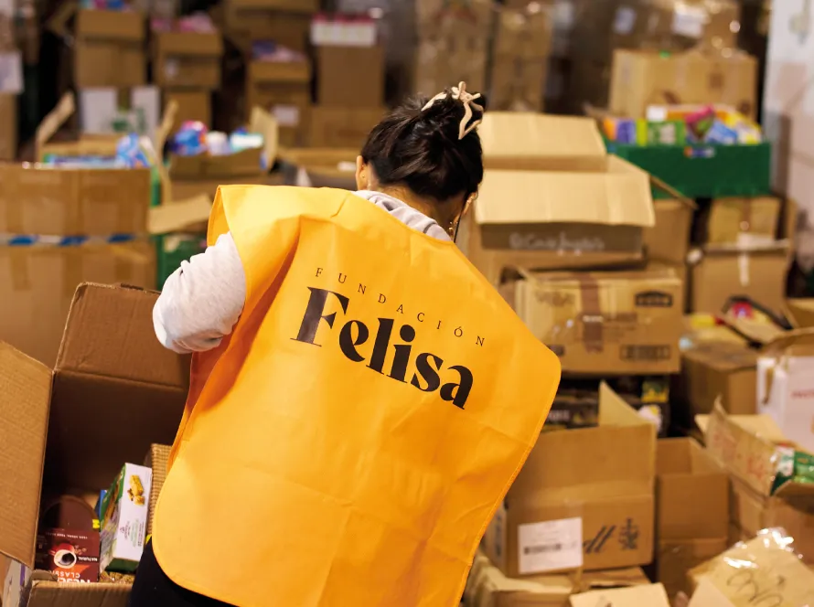 Voluntaria con el chaleco de Fundación Felisa clasificando cajas de donaciones
