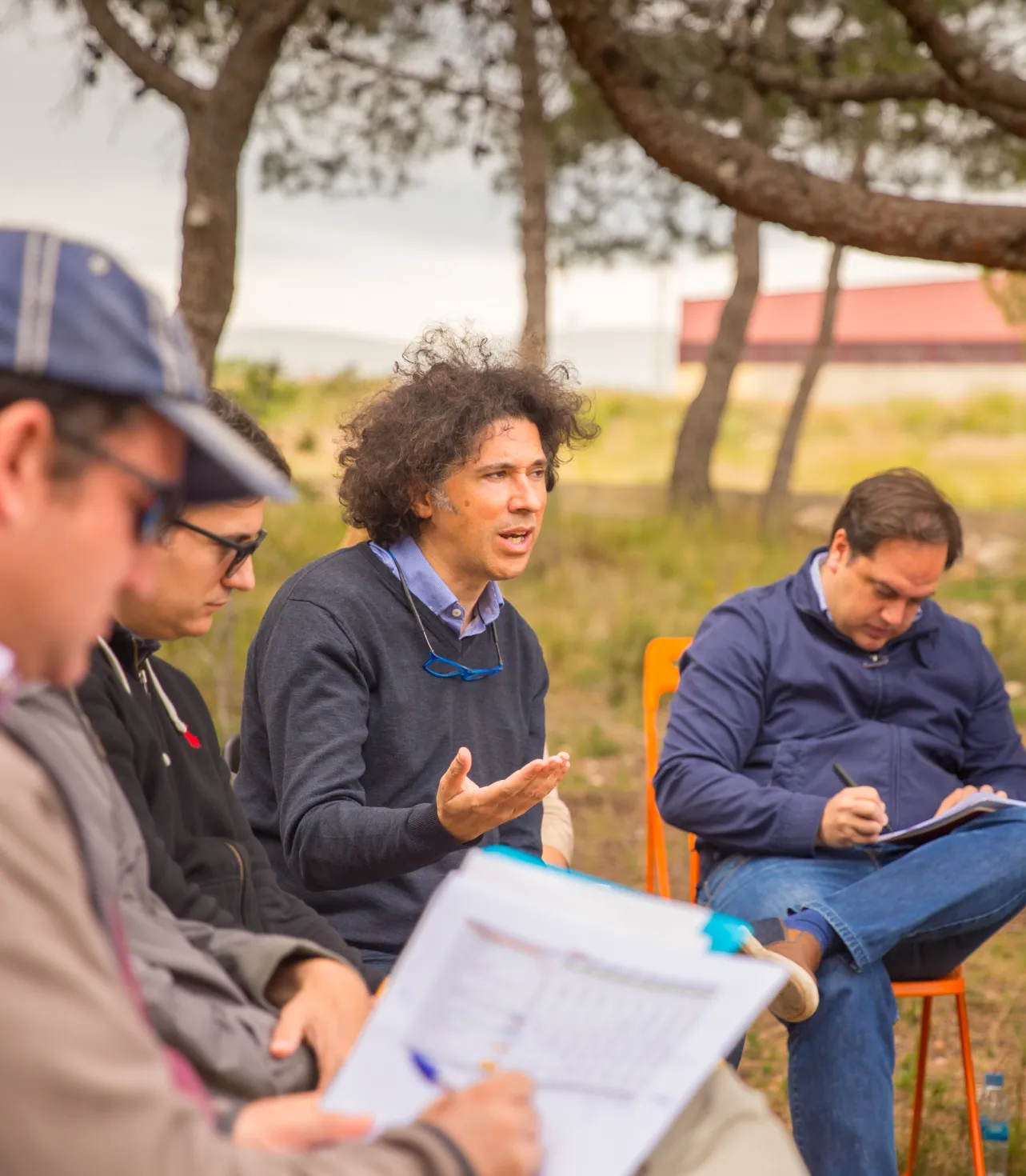 Grupo de personas sentadas al aire libre en una sesión de mentoría empresarial