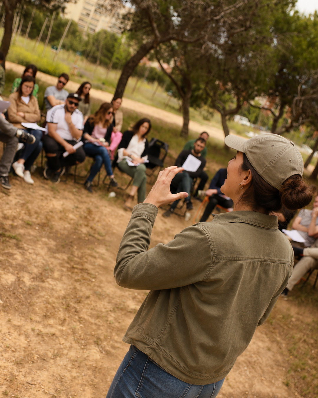 Persona dinamizando un taller con participantes al aire libre